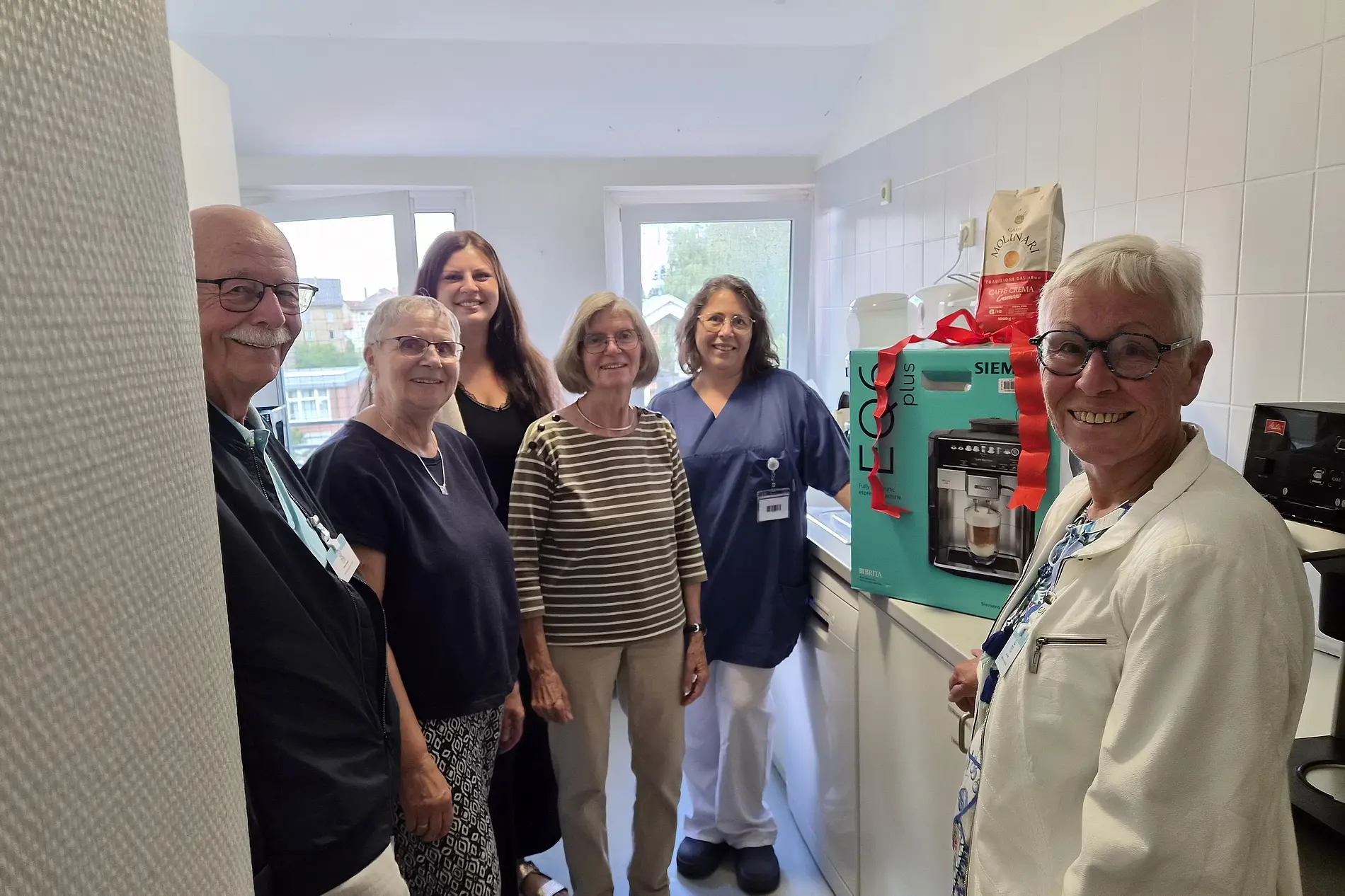 Mitlglieder der Diakonischen Gemeinschaft übergeben Kaffeevollautomaten an Sabine Kohl von der Palliativstation
